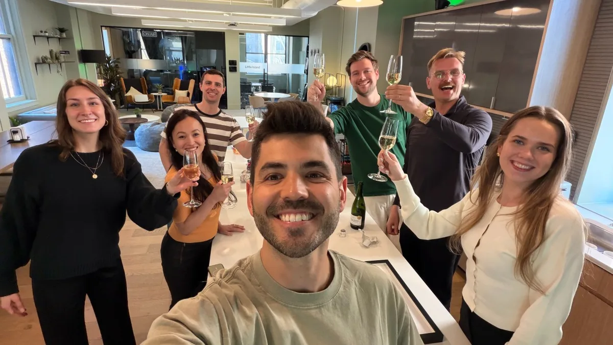 The Optimizely team raising champagne glasses in the office
